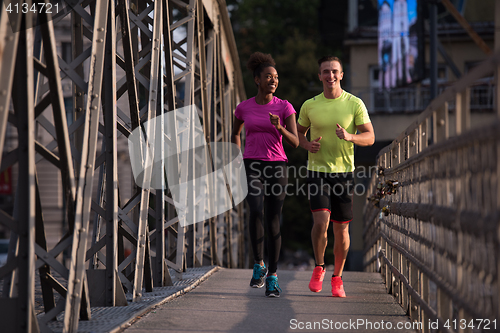 Image of multiethnic couple jogging in the city