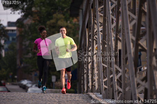 Image of multiethnic couple jogging in the city