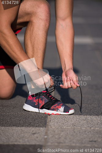 Image of Young athlete, runner tie shoelaces in shoes