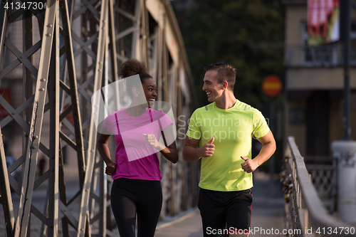 Image of multiethnic couple jogging in the city