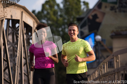 Image of multiethnic couple jogging in the city