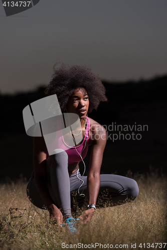 Image of black woman runner tightening shoe lace