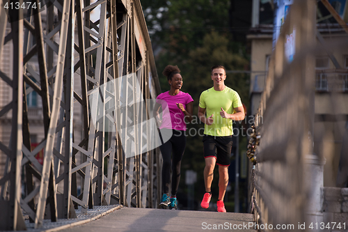 Image of multiethnic couple jogging in the city