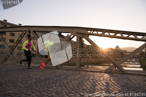 Image of young multiethnic couple jogging in the city