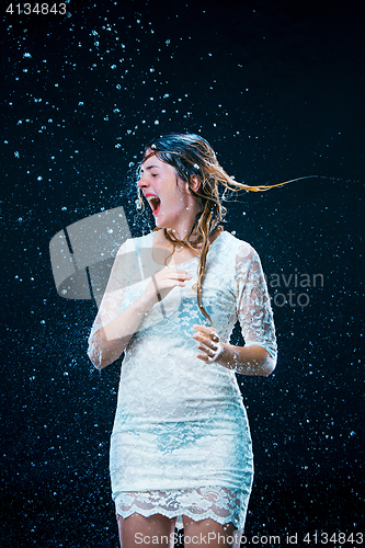 Image of The young girl standing under running water