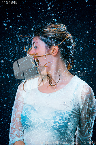 Image of The young girl standing under running water