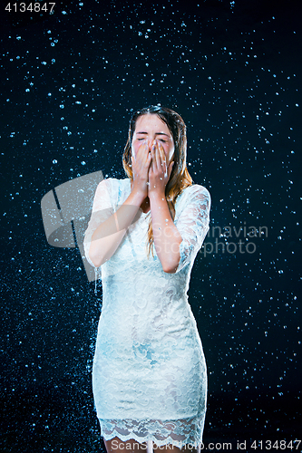 Image of The young girl standing under running water