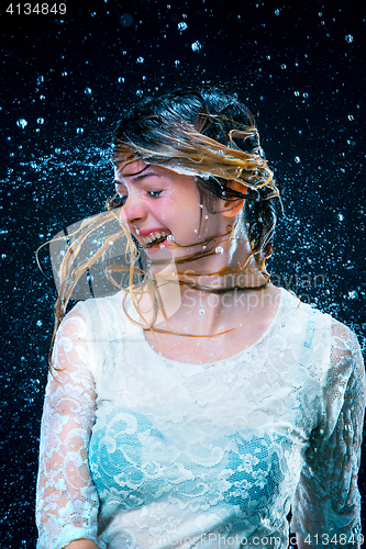 Image of The young girl standing under running water