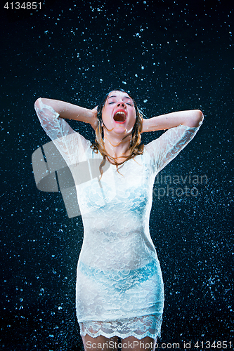 Image of The young girl standing under running water