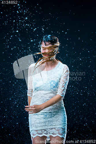 Image of The young girl standing under running water