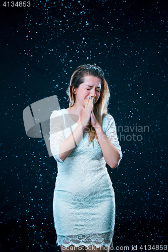 Image of The young girl standing under running water