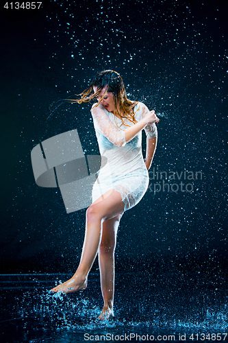 Image of The young girl standing under running water