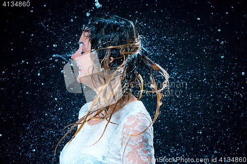 Image of The young girl standing under running water