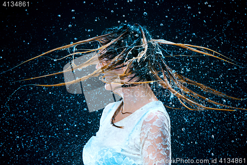 Image of The young girl standing under running water