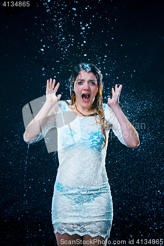 Image of The young girl standing under running water