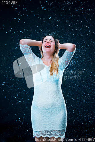 Image of The young girl standing under running water