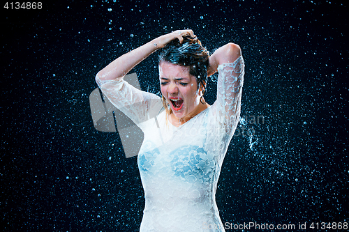 Image of The young girl standing under running water