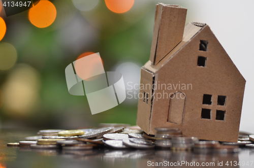 Image of Model of house with coins on wooden table