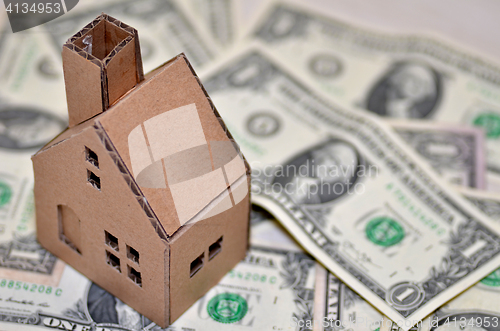 Image of Miniature paper made house stand on  money