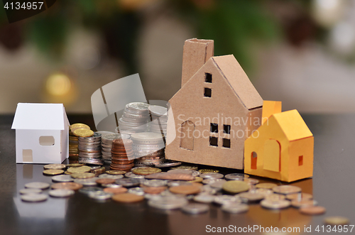 Image of Paper house and stacks of coins standing