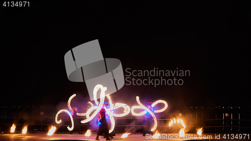 Image of Artists juggling with burning poi\'s at fire performance.