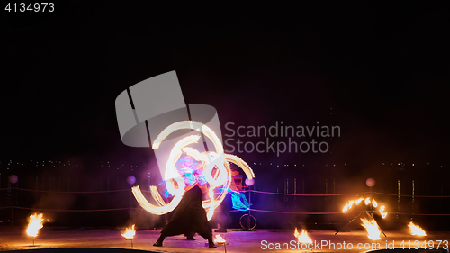 Image of Artists juggling with burning poi\'s at fire performance.