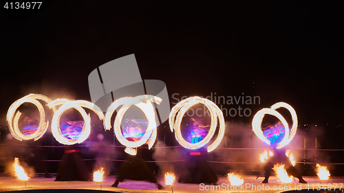 Image of Artists juggling with burning poi\'s at fire performance.
