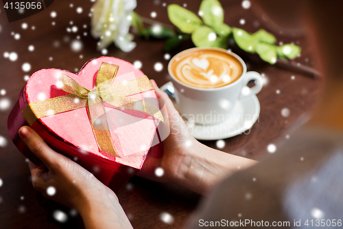 Image of hands holding heart shaped gift box