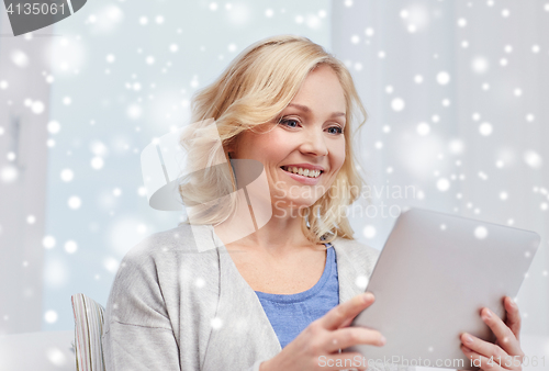 Image of happy middle aged woman with tablet pc at home