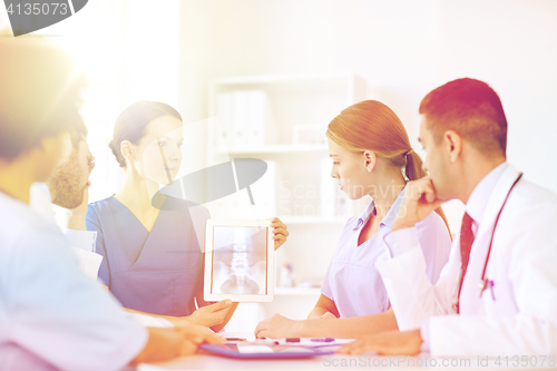 Image of group of doctors with x-ray on tablet pc at clinic