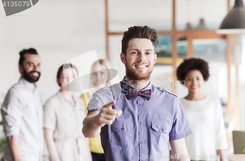 Image of happy man pointing finger at you over office team