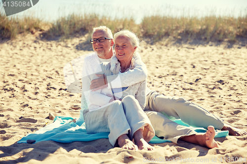 Image of happy senior couple hugging on summer beach