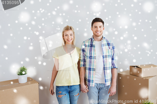 Image of smiling couple with big boxes moving to new home