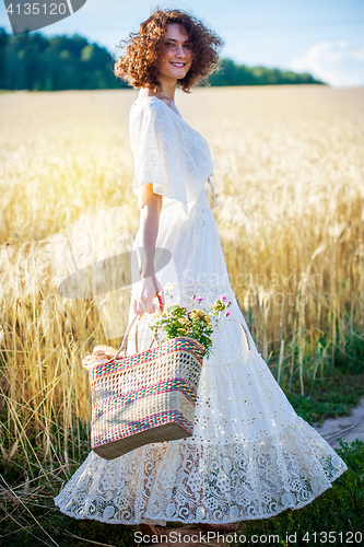 Image of beautiful smiling woman in white syled dress outdoors