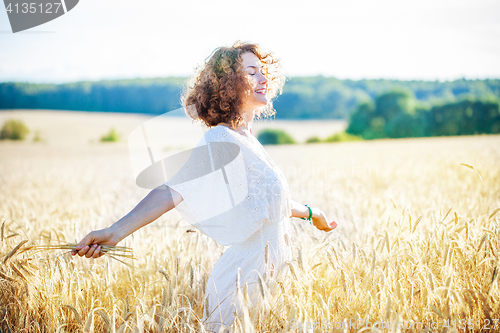Image of smiling happy woman in wheat field