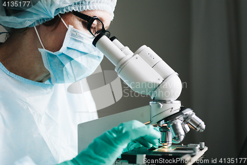 Image of Scientist working in laboratory with microscope