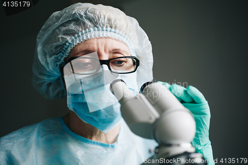 Image of Scientist working in laboratory with microscope