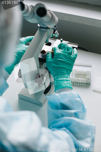 Image of Crop hands putting microscope glasses in box