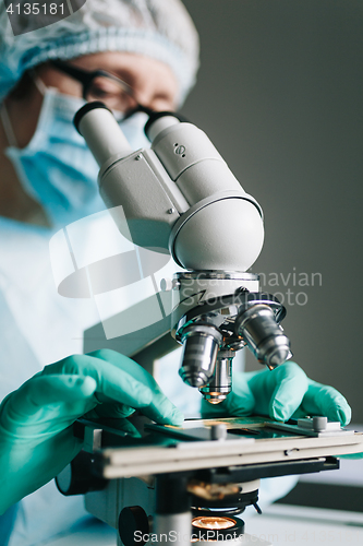 Image of Scientist working in laboratory with microscope