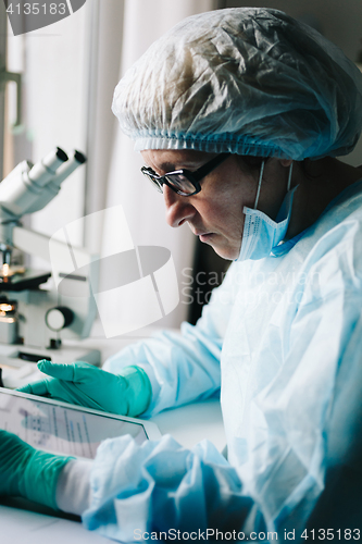 Image of Side view of scientist working on tablet