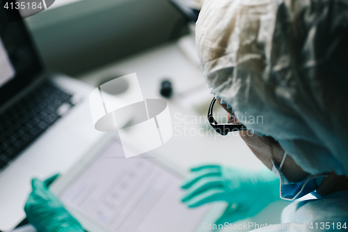 Image of Back view of scientist working on tablet