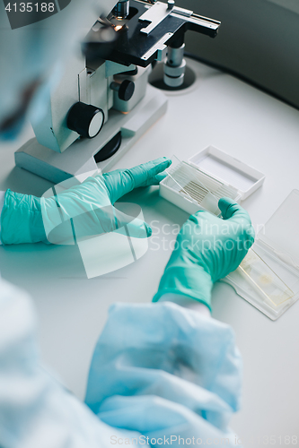 Image of Crop hands putting microscope glasses in box