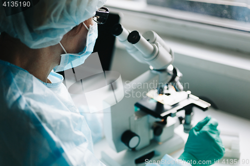 Image of Scientist working in laboratory with microscope