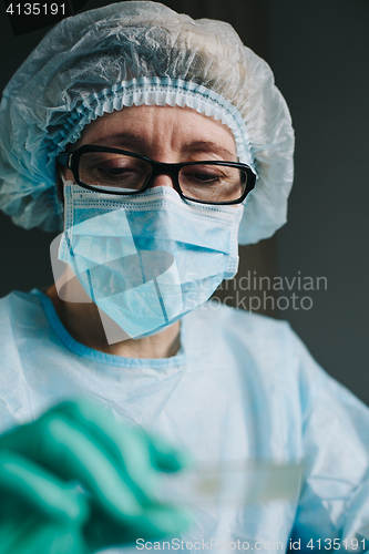 Image of Crop hands putting microscope glasses in box