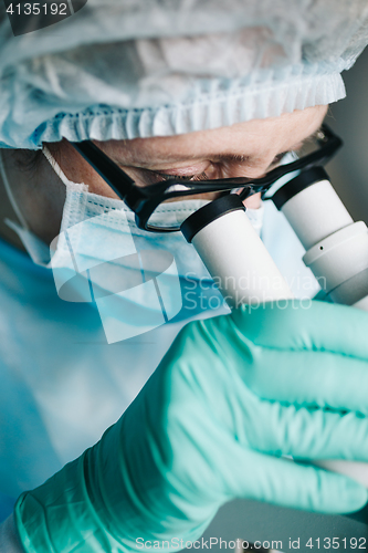 Image of Scientist working in laboratory with microscope