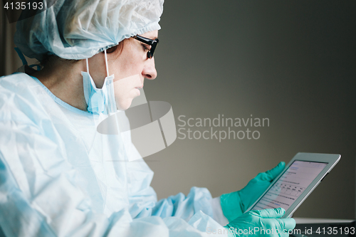 Image of Side view of scientist working on tablet