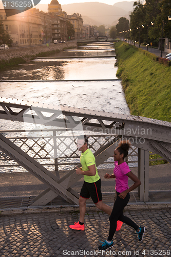 Image of young multiethnic couple jogging in the city