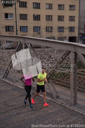 Image of young multiethnic couple jogging in the city