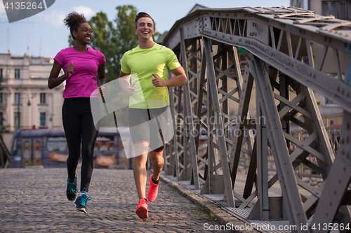 Image of multiethnic couple jogging in the city
