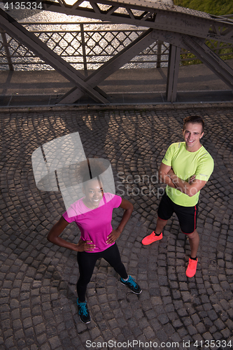 Image of portrait of a young multiethnic couple jogging in the city